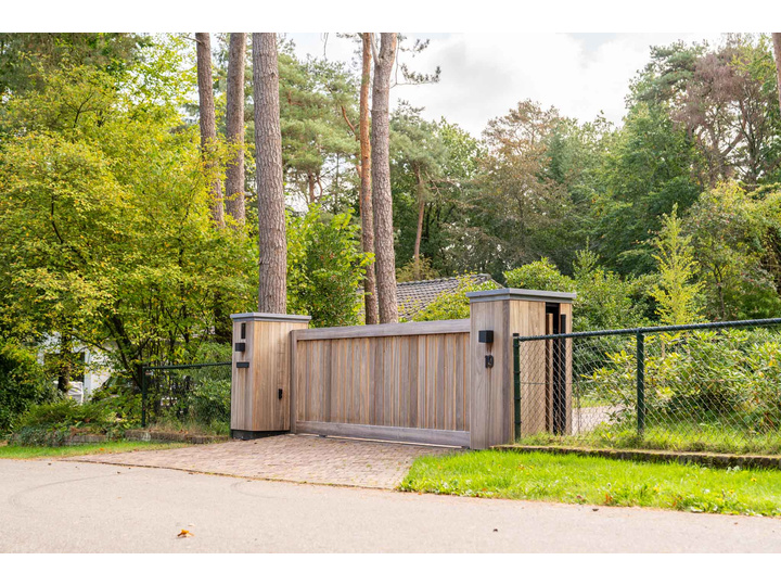 Moderne Padouk schuifpoort met subtiele doorkijk