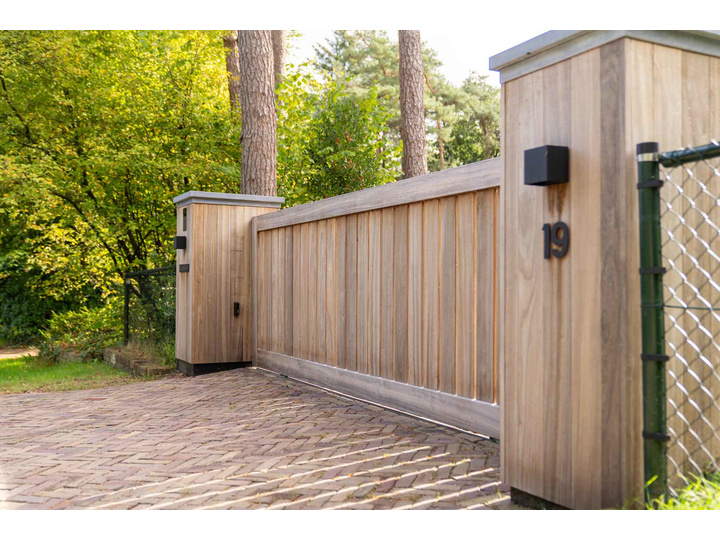Moderne Padouk schuifpoort met subtiele doorkijk